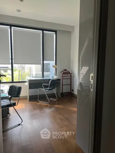 Modern study room with large windows and sleek furniture, perfect for productivity and comfort.