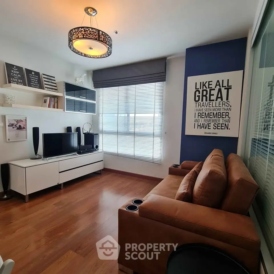 Modern living room with stylish decor and cozy seating area, featuring a large window and elegant lighting.