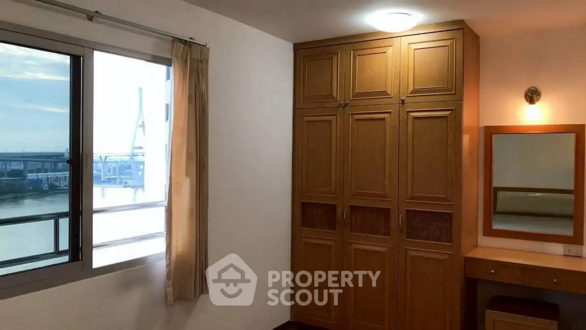 Cozy bedroom with wooden wardrobe and river view window