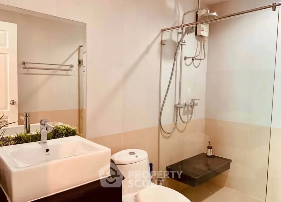 Modern bathroom with glass shower and sleek fixtures in a contemporary home.