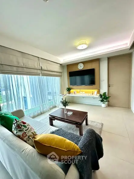 Modern living room with stylish decor and large windows offering natural light.