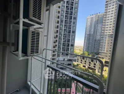Urban apartment balcony with cityscape view and modern high-rise buildings.