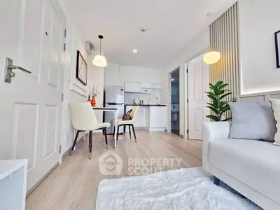 Bright and modern living room with open kitchen layout and stylish decor.