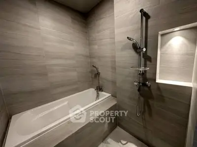 Modern bathroom with sleek gray tiles and built-in bathtub