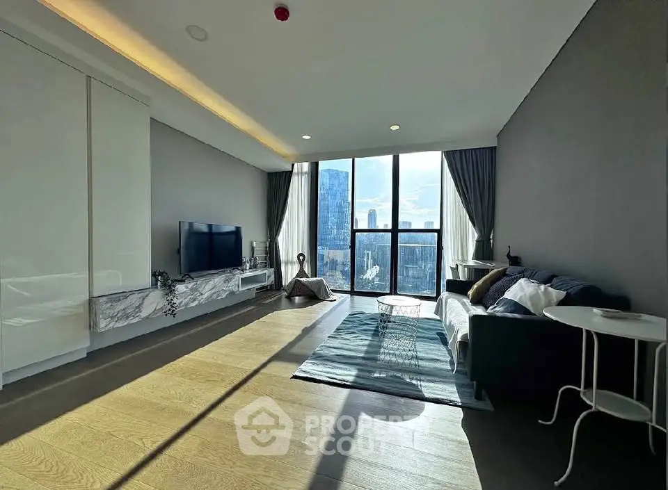 Spacious modern living room with large windows and city view, featuring stylish decor and natural light.