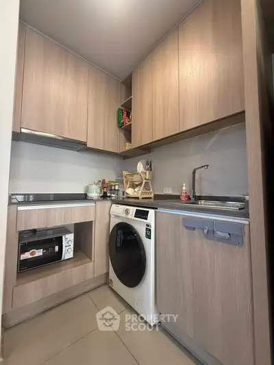 Modern kitchen with integrated appliances and sleek cabinetry in compact layout.