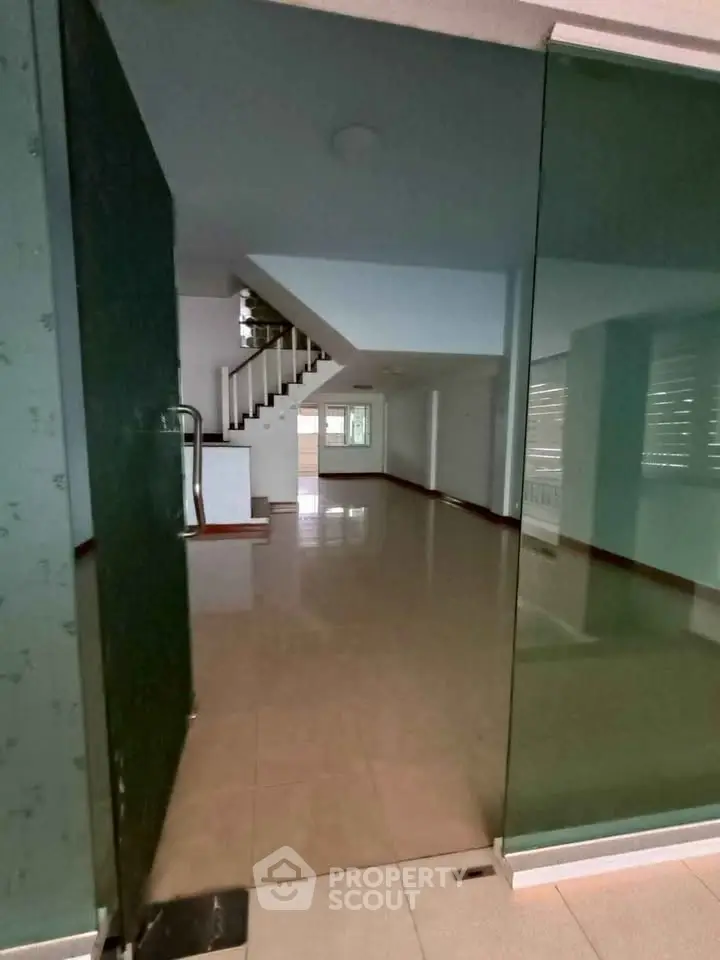 Spacious open-plan interior with staircase and large windows, ideal for modern living.