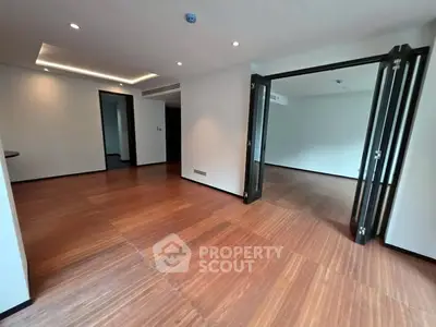 Spacious modern living room with wooden flooring and folding doors, perfect for open-plan living.