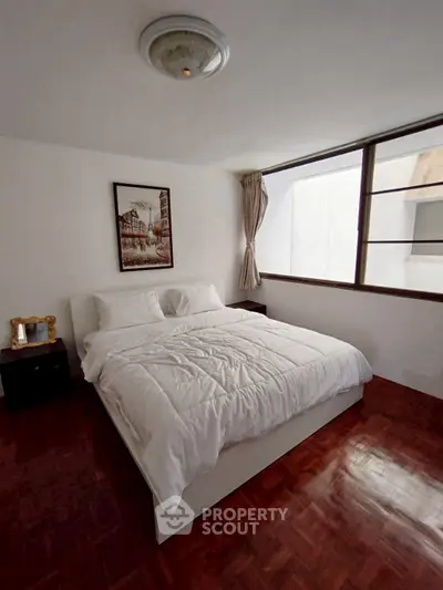 Cozy bedroom with large window and elegant decor in modern apartment