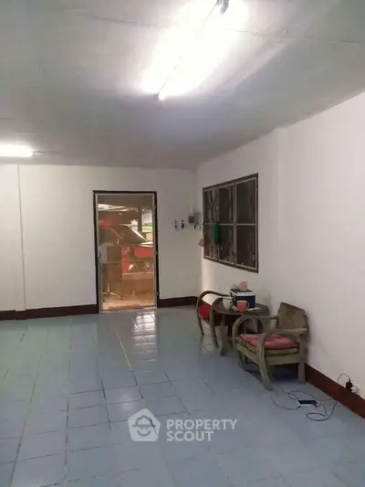 Spacious interior room with tiled flooring and simple furnishings, ideal for customization.