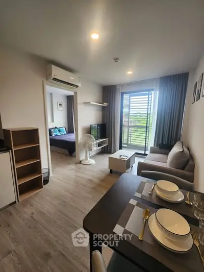 Modern open-plan living room with dining area and view of bedroom, featuring stylish decor and natural light.