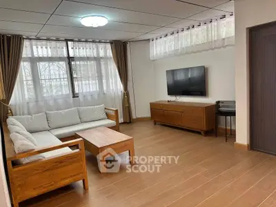 Spacious living room with modern wooden furniture and wall-mounted TV