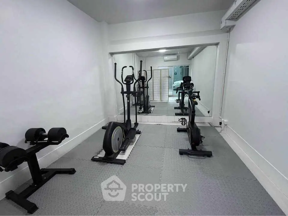 Modern home gym with exercise equipment and mirrored wall