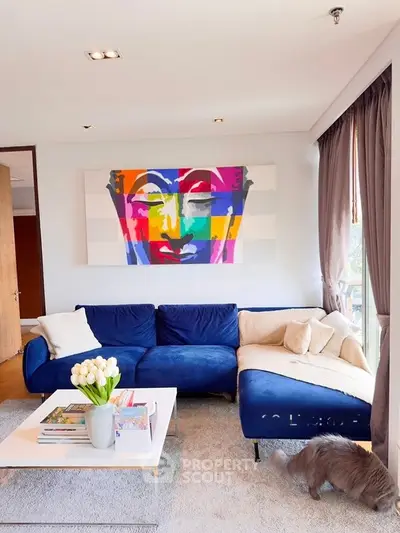 Stylish living room with vibrant artwork and cozy blue sofa