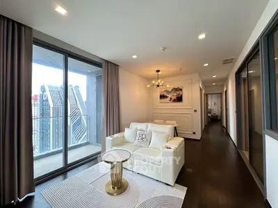 Luxurious living room with modern decor and stunning city view from balcony.
