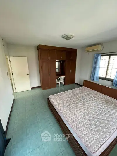Spacious bedroom with large wardrobe and natural light, ideal for comfort and relaxation.