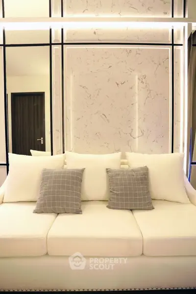 Elegant modern living room with stylish white sofa and decorative pillows.