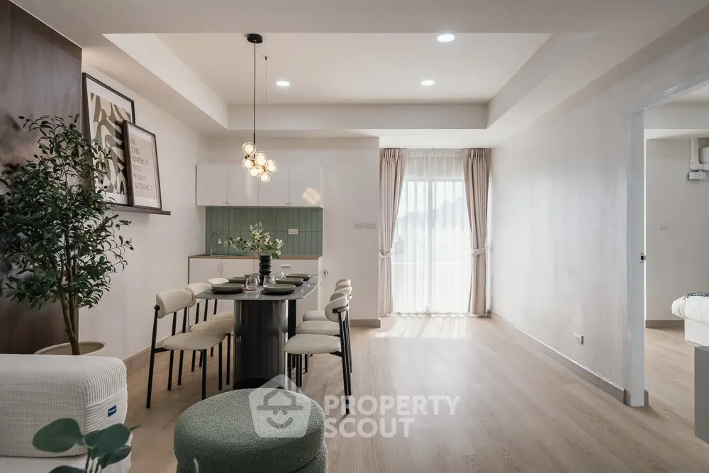 Modern dining area with elegant lighting and natural light from large window