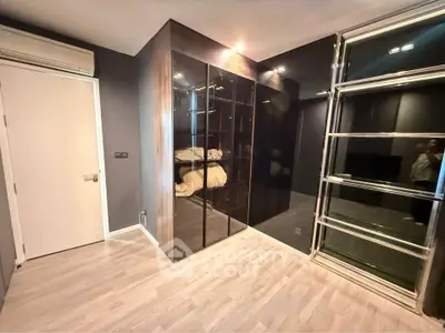 Modern bedroom with sleek glass wardrobe and wooden flooring