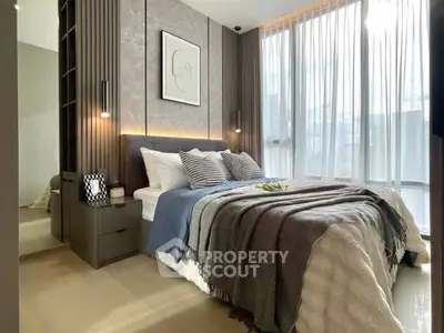 Modern bedroom with large windows and stylish decor, featuring cozy bedding and elegant lighting.