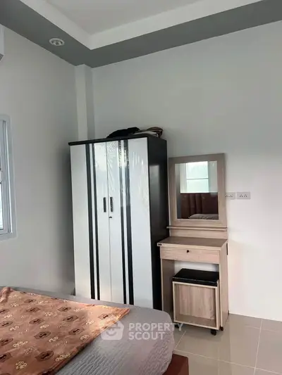Cozy bedroom with modern wardrobe and vanity set, perfect for stylish living.