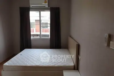 Cozy bedroom with natural light and modern air conditioning unit, perfect for restful nights.
