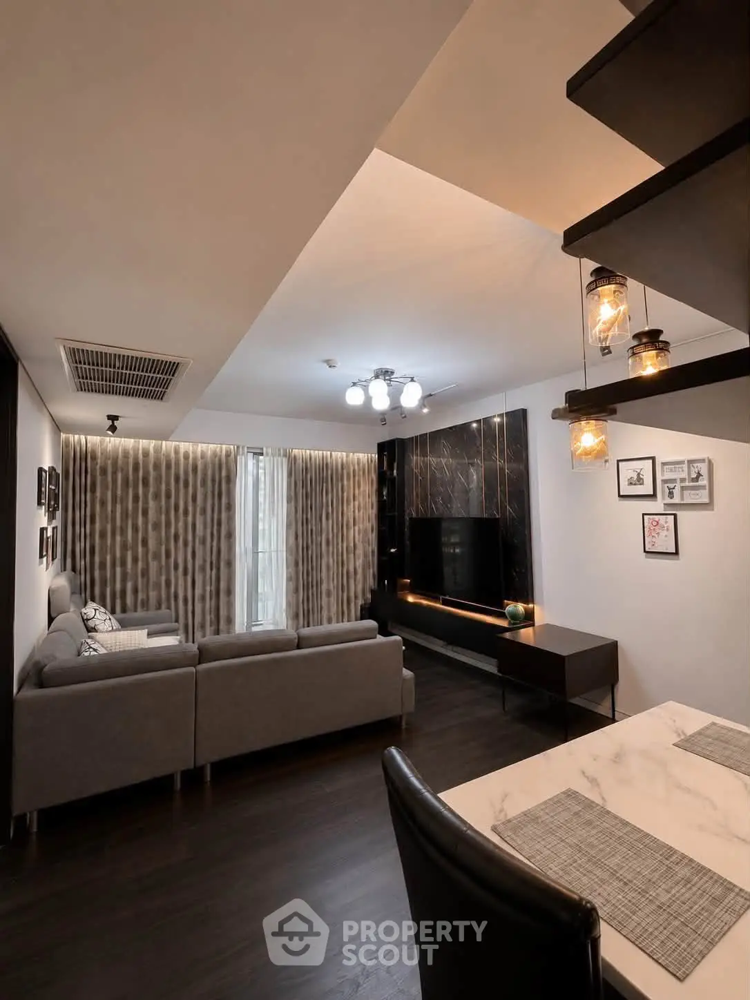 Modern living room with stylish decor, large sofa, and elegant lighting, perfect for relaxation and entertainment.