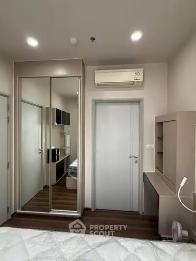 Modern bedroom with mirrored closet and air conditioning in stylish apartment