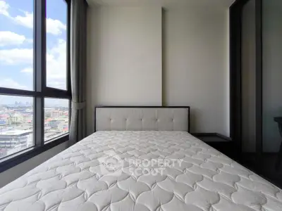 Modern bedroom with large window offering stunning city views