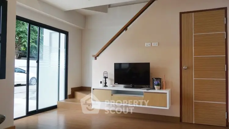 Modern living room with sleek TV setup and wooden flooring