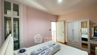 Spacious bedroom with elegant decor and ample natural light, featuring a stylish wardrobe and comfortable bedding.