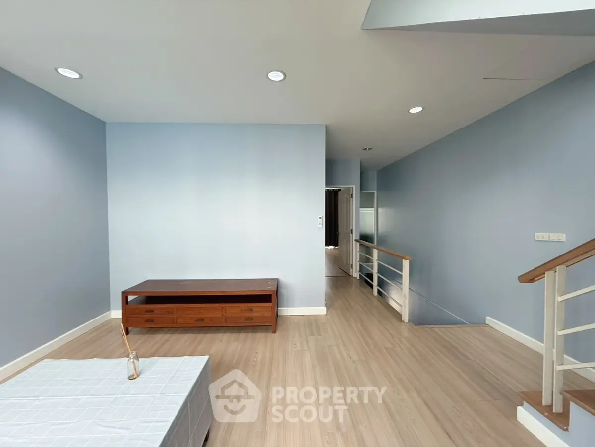 Spacious living room with modern wooden flooring and sleek staircase