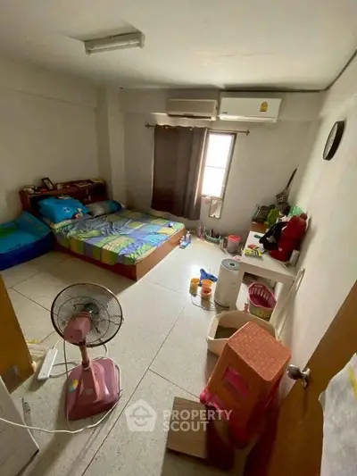 Cozy bedroom with air conditioning and colorful bedding, ideal for comfortable living.