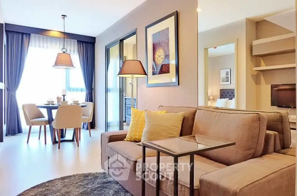 Modern living room with cozy sofa, stylish decor, and dining area in open layout apartment.