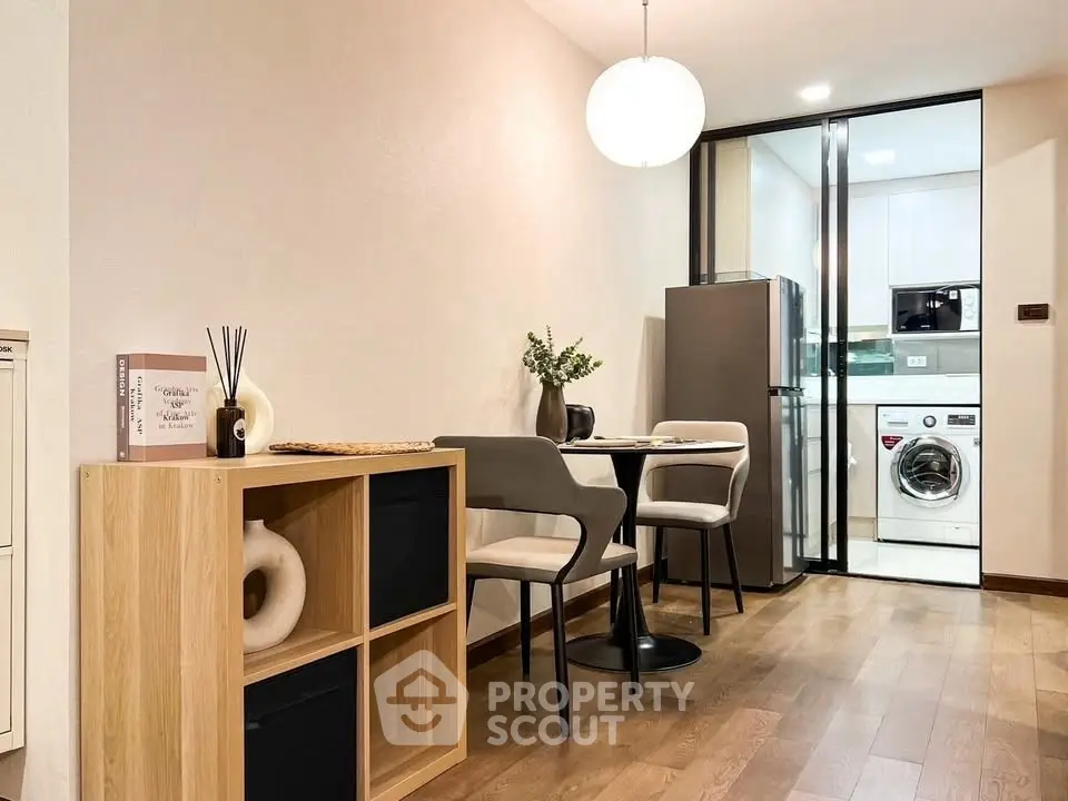 Modern dining area with washing machine and fridge in open layout kitchen