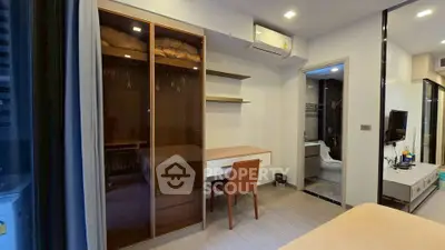 Modern bedroom with built-in wardrobe and study desk, featuring sleek design and ample storage space.