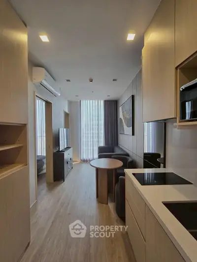 Modern apartment interior with sleek kitchen and cozy living area, featuring floor-to-ceiling windows.