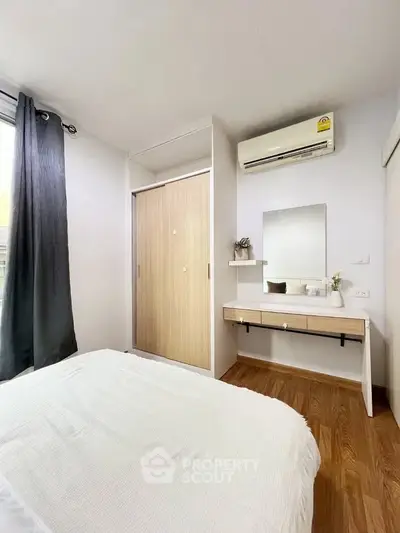 Modern bedroom with wooden flooring and sleek furniture design