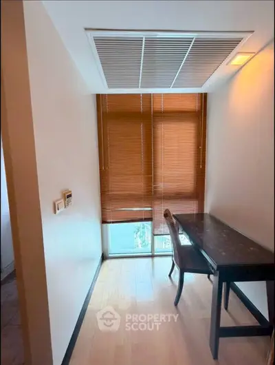 Cozy study nook with natural light and wooden blinds, perfect for focused work or reading.