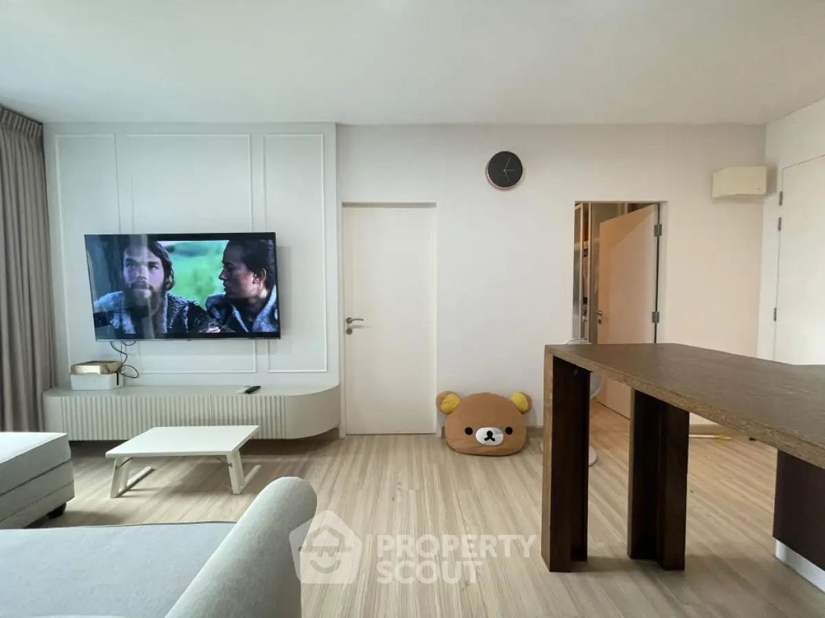 Modern living room with wall-mounted TV and stylish furniture