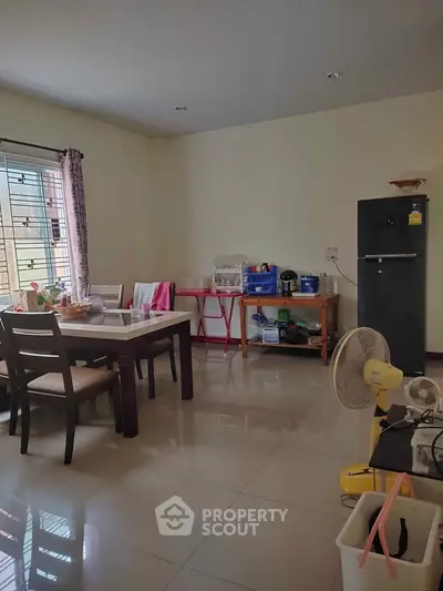 Spacious dining area with modern furniture and natural light, perfect for family gatherings.