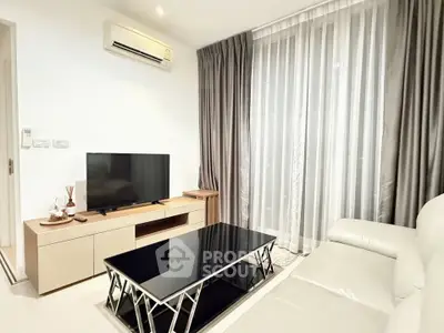 Modern living room with sleek furniture and large window drapes, featuring a TV and air conditioning.