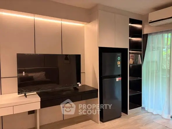 Modern living room with sleek TV unit and fridge, featuring stylish shelving and ambient lighting.