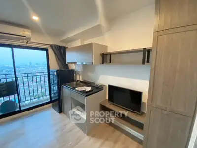 Modern apartment kitchen with city view balcony, sleek cabinetry, and compact design.