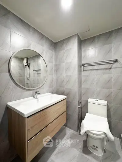 Modern bathroom with sleek design and round mirror in a stylish apartment.