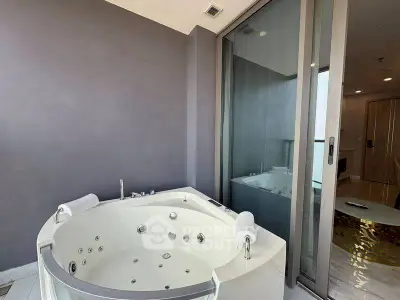 Luxurious balcony with private jacuzzi and modern glass door access.