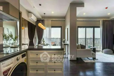Modern open-plan living room with balcony and washing machine, featuring elegant decor and natural light.