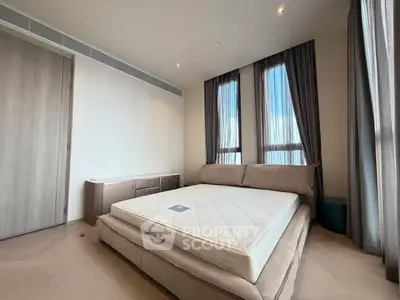 Spacious bedroom with large windows and modern bed in a stylish apartment.