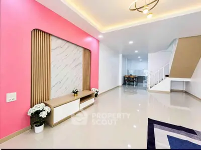 Modern living room with stylish pink accent wall and elegant staircase