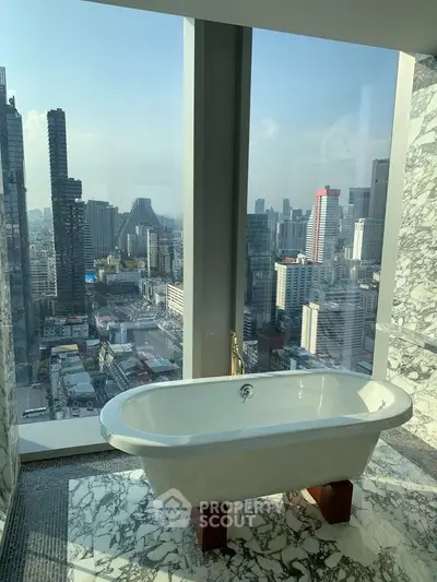 Luxurious bathroom with freestanding bathtub and stunning city skyline view.